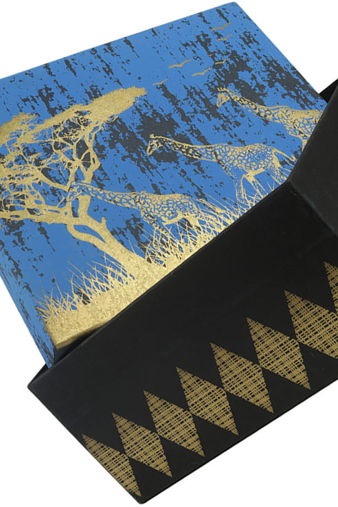 A novel square gift box  in black and blue with a gold design of giraffes on the savanah