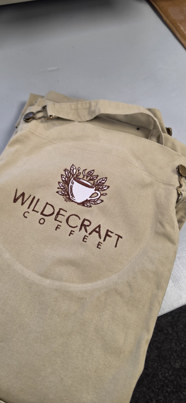 Wildecraft Coffee logo embroidered on a beige polo shirt by The Thread Studio