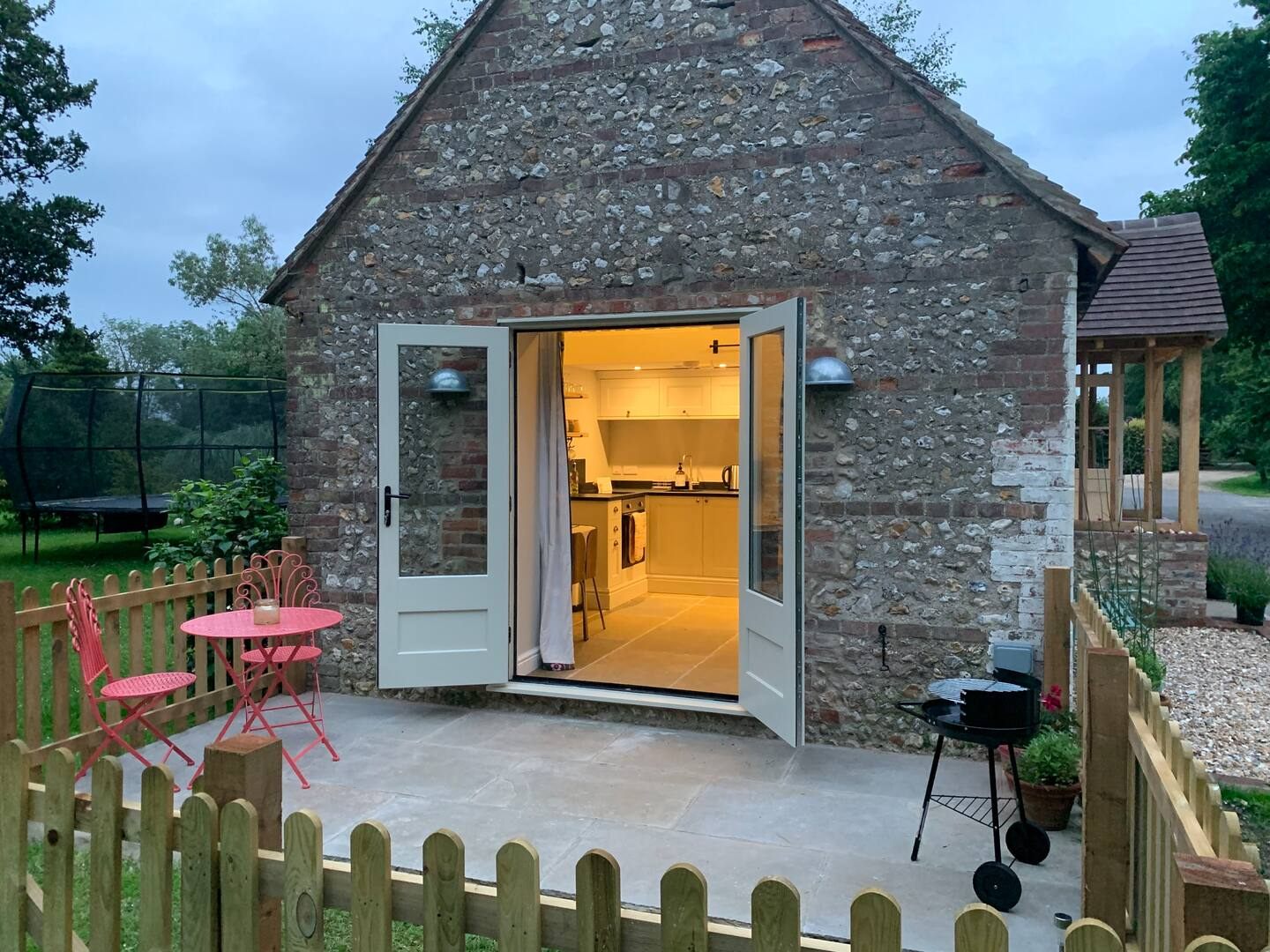 Limestone patio outside a converted flint barn at dusk