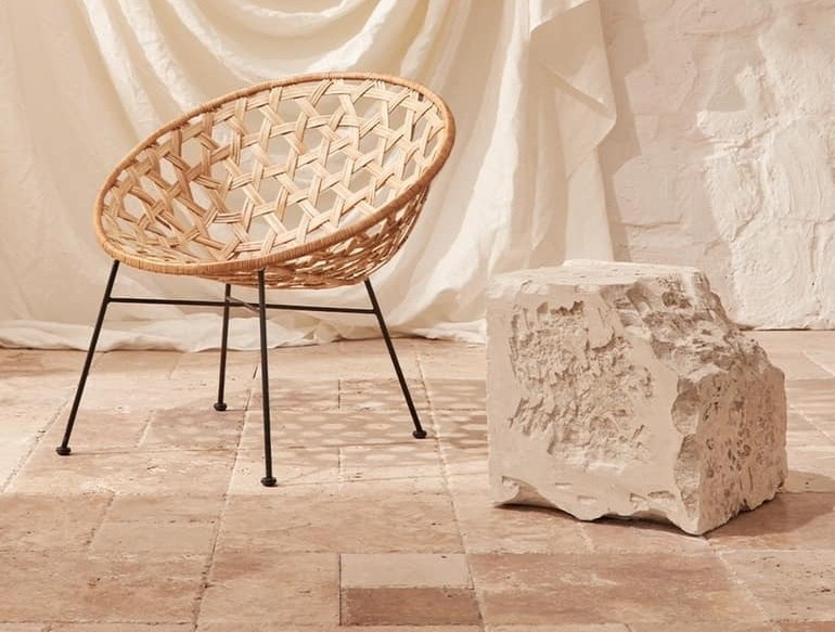 Tumbled travertine floor with a rattan chair and raw travertine block